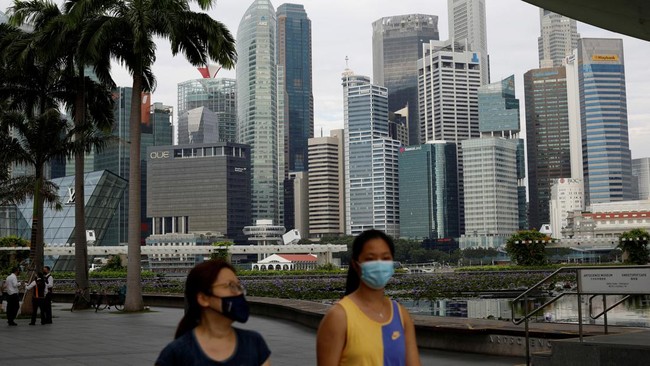 warga-yang-memakai-masker-wajah-melewati-cakrawala-kota-selama-wabah-penyakit-coronavirus-covid-19-di-singapura-reutersedgar-s_169