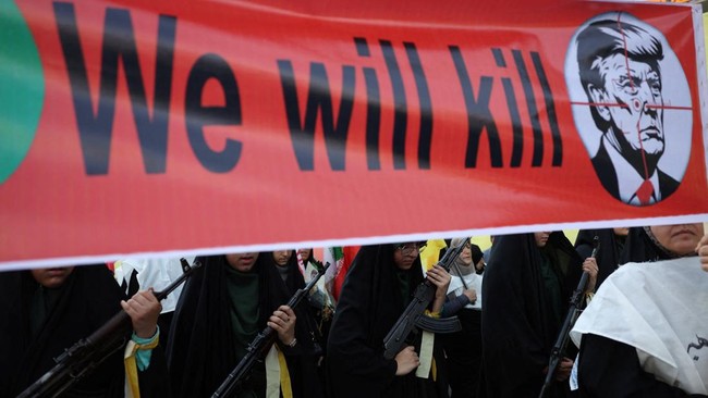 anggota-perempuan-pasukan-milisi-iran-basij-membawa-spanduk-yang-menentang-presiden-as-donald-trump-saat-pawai-militer-di-tehe-1789732651704_169
