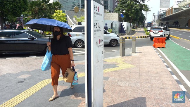 pejalan-kaki-menggunakan-payung-untuk-menghindari-terik-matahari-di-kawasan-jembatan-pinisi-di-halte-busway-karet-jakarta-sela-3_169