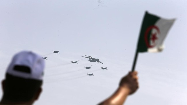 seorang-pria-melambaikan-bendera-aljazair-saat-pesawat-tempur-terbang-selama-parade-militer-untuk-menandai-peringatan-60-tahun-1742974810408_169