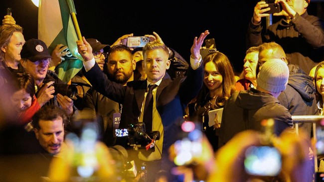 peter-magyar-pemimpin-partai-oposisi-tisza-mengangkat-bendera-hungaria-saat-merayakan-kemenangan-setelah-perdana-menteri-hunga-1776085074508_169