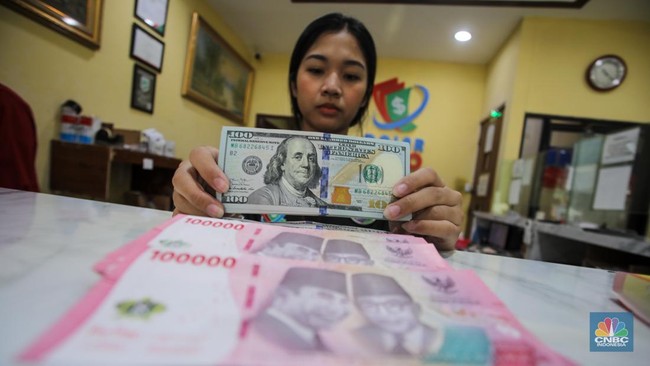petugas-menjunjukkan-uang-pecahan-dolar-as-dan-rupiah-di-dolarindo-money-changer-jakarta-selasa-842025-1744086432396_169