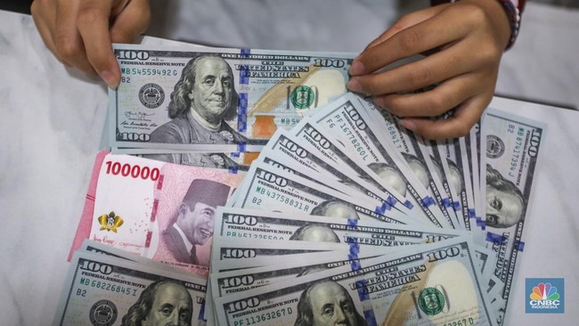 petugas-menjunjukkan-uang-pecahan-dolar-as-dan-rupiah-di-dolarindo-money-changer-jakarta-selasa-842025-1744086561018_169