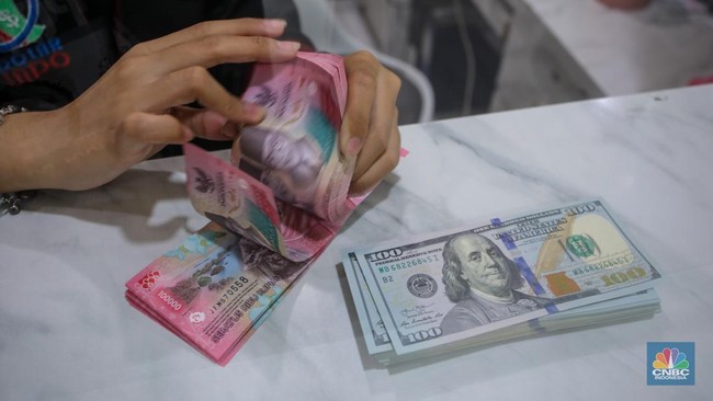 petugas-menjunjukkan-uang-pecahan-dolar-as-dan-rupiah-di-dolarindo-money-changer-jakarta-selasa-842025-1744086561343_169