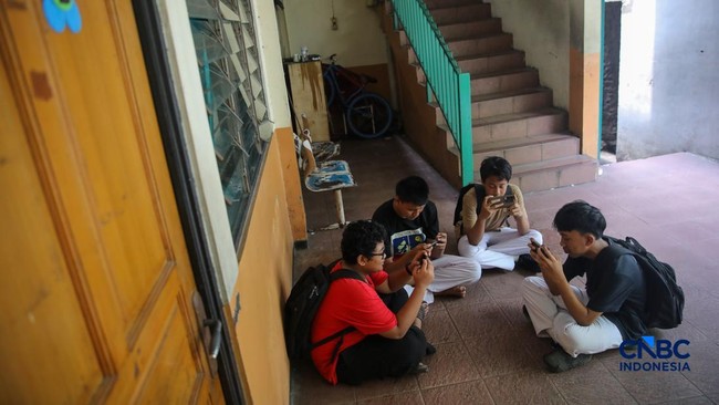sejumlah-anak-memainkan-ponsel-mereka-sesuai-pulang-sekolah-di-jakarta-senin-3032026-pemerintah-resmi-melarang-anak-di-bawah-u-1774857452543_169