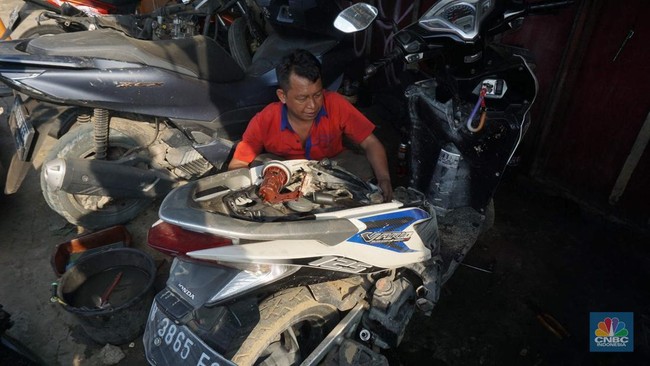 seorang-montir-memperbaiki-motor-yang-rusak-terendam-banjir-di-kawasan-bekasi-jawa-barat-rabu-532025-cnbc-indonesiamuhammad-sa-1741176834482_169