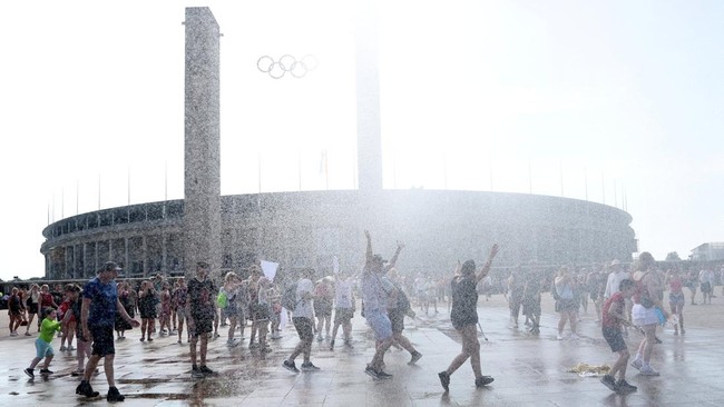 orang-orang-menikmati-semprotan-air-dari-meriam-air-polisi-di-depan-stadion-olimpiade-olympiastadion-selama-gelombang-panas-ya-1782710504132_169