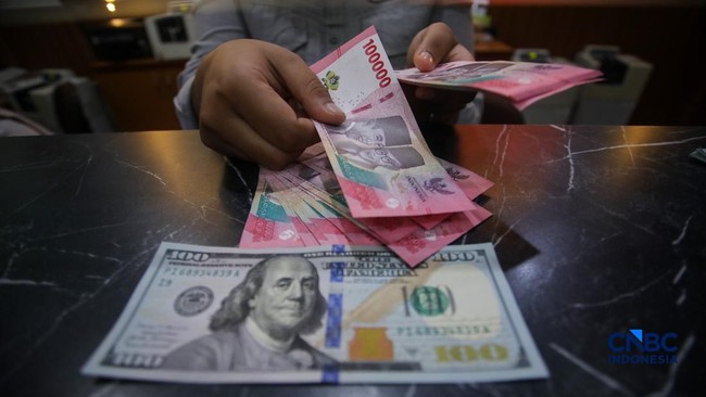 petugas-menjunjukkan-uang-pecahan-dolar-amerika-serikat-as-dan-rupiah-di-dolar-asia-money-changer-jakarta-rabu-872026-1783496342975_169