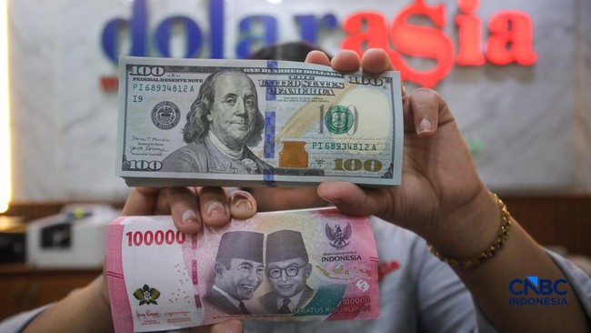 petugas-menjunjukkan-uang-pecahan-dolar-amerika-serikat-as-dan-rupiah-di-dolar-asia-money-changer-jakarta-rabu-872026-1783496341961_169