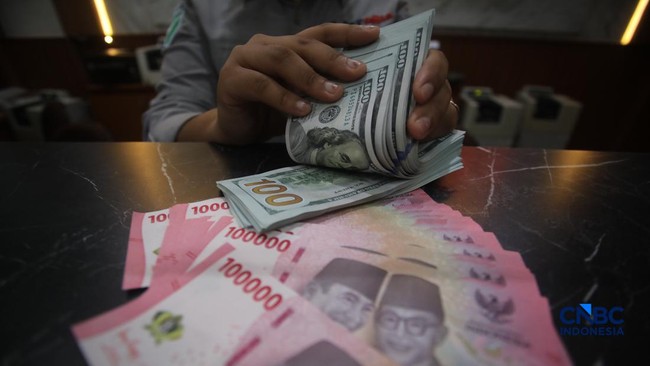 petugas-menjunjukkan-uang-pecahan-dolar-amerika-serikat-as-dan-rupiah-di-dolar-asia-money-changer-jakarta-rabu-872026-1783496342314_169
