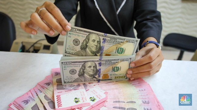 petugas-menunjukkan-uang-pecahan-dolar-as-dan-rupiah-di-gerai-penukaran-mata-uang-asing-di-tempat-penukaran-uang-pt-ayu-masagu-2_169