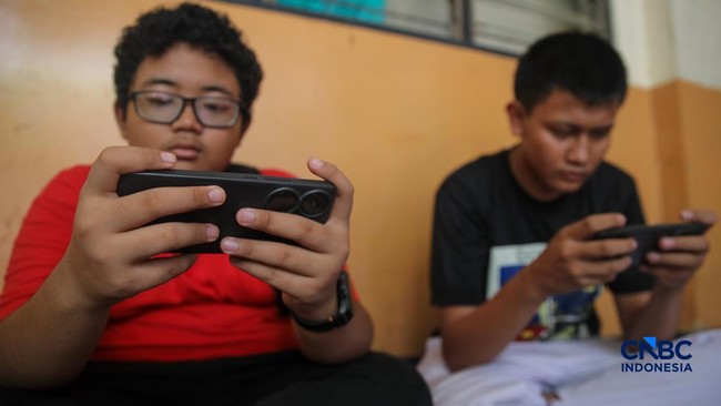 sejumlah-anak-memainkan-ponsel-mereka-sesuai-pulang-sekolah-di-jakarta-senin-3032026-pemerintah-resmi-melarang-anak-di-bawah-u-1774857452764_169